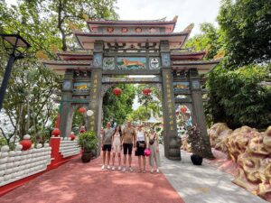 Tour participants stand beneath the ornate entrance arch of Haw Par Villa in Singapore